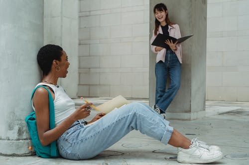 不同的学生在做作业时笑 · 免费素材图片