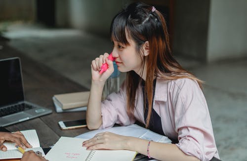 有标记和笔记本的年轻亚裔学生 · 免费素材图片