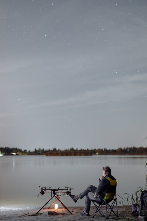 黑色和粉红色夹克在湖上钓鱼的人 · 免费素材图片