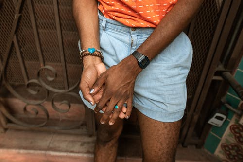 灰色短裤和橙色衬衫的男人与女人穿着橙色衬衫手牵着手 · 免费素材图片