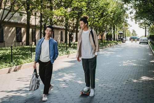 开朗的多种族男性朋友一起在铺好的人行道上行走 · 免费素材图片