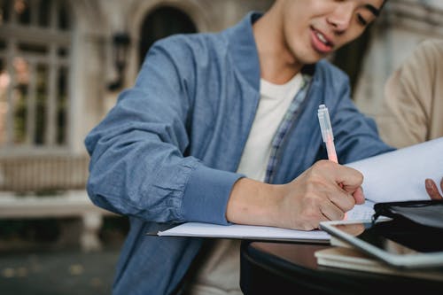 族裔学生和同学在公园里做作业 · 免费素材图片