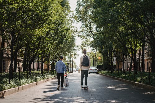 男性滑板附近的朋友在公园里骑 · 免费素材图片