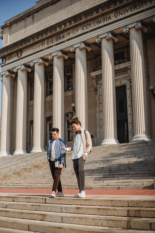 两名男子站在大学大楼外 · 免费素材图片