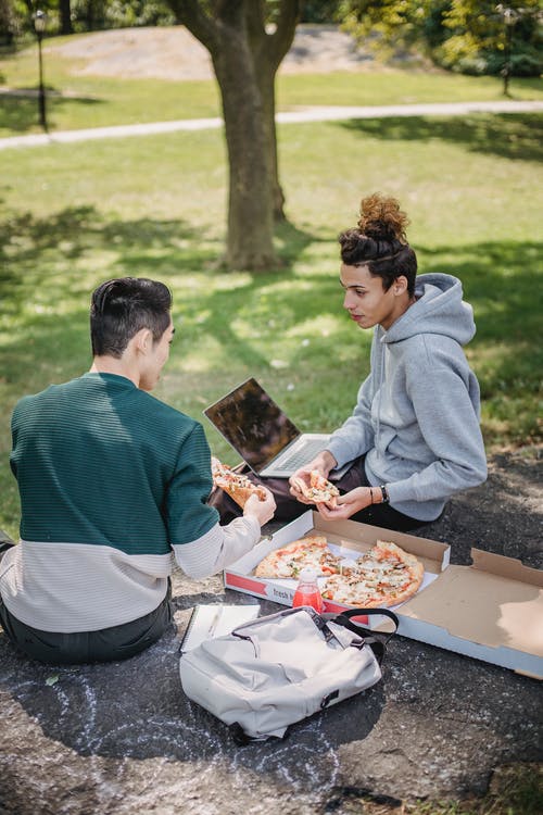 男人和女人吃东西时坐在长椅上 · 免费素材图片