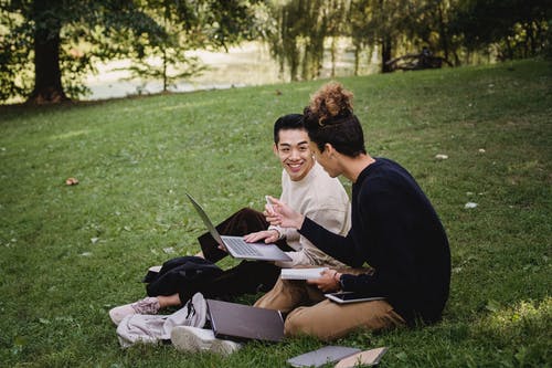 快乐的民族男学生在公园里做作业 · 免费素材图片
