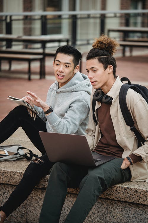 坐在灰色外套使用macbook的女人旁边的灰色连帽衫的男人 · 免费素材图片