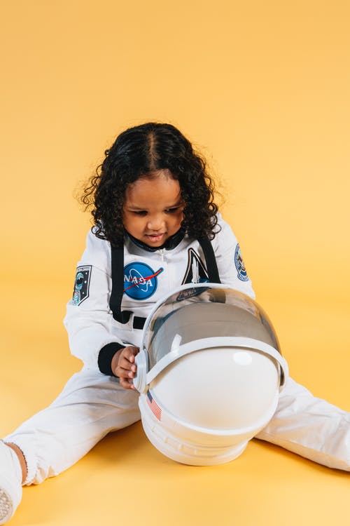 拿着白色塑料桶的白色和黑色外套的男孩 · 免费素材图片