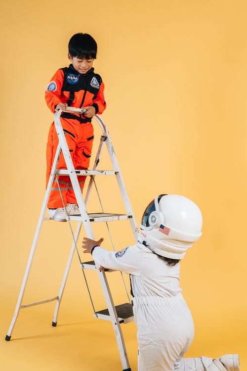 白色长袖衬衫和橙色头盔站在梯子上的男人 · 免费素材图片