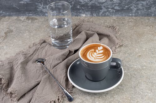 有关一杯水, 咖啡, 小碟子的免费素材图片