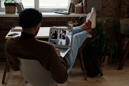 坐在椅子上看报纸的棕色毛衣的男人 · 免费素材图片