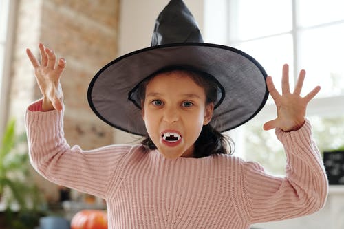 吸血鬼犬牙和巫婆帽子服装的女孩 · 免费素材图片