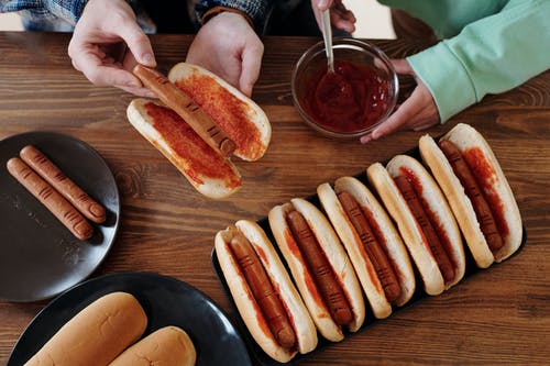 棕色的木桌上的热狗三明治 · 免费素材图片