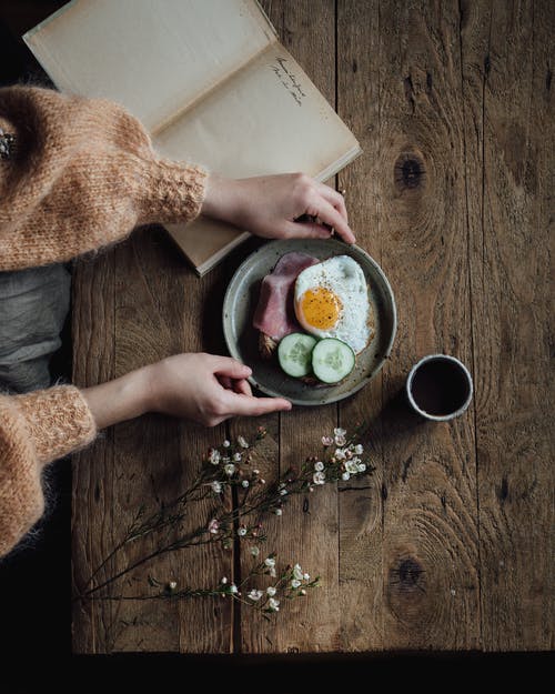 作物女人在桌上的书和早餐 · 免费素材图片
