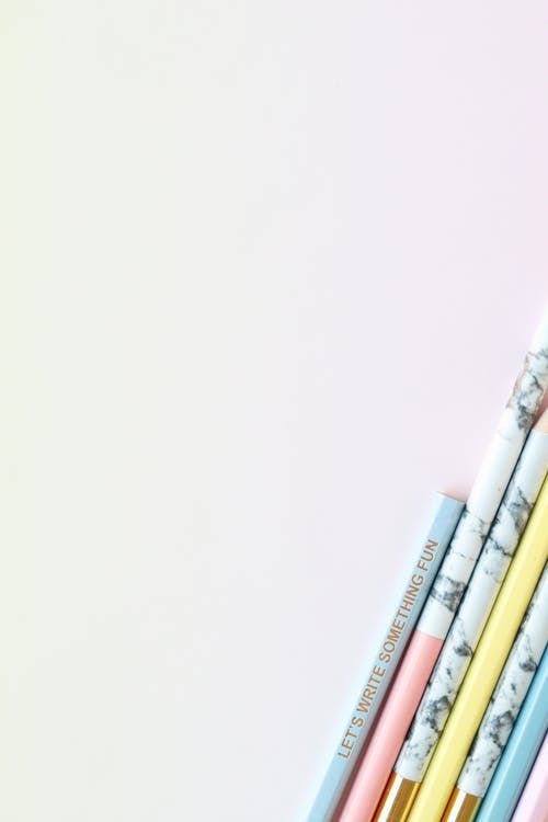 白色表面上的白色和红色铅笔 · 免费素材图片
