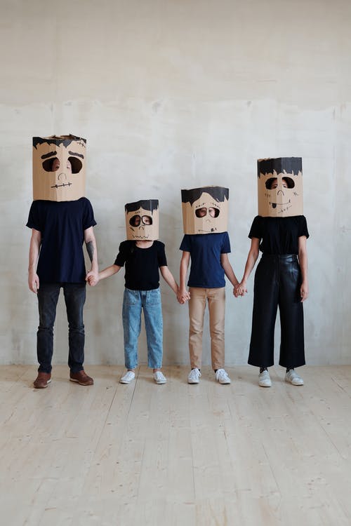 一家人互相握着手戴diy纸板盒面膜 · 免费素材图片