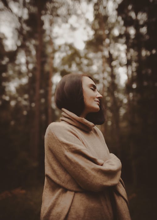 梦幻般的女人站在秋天的树林 · 免费素材图片