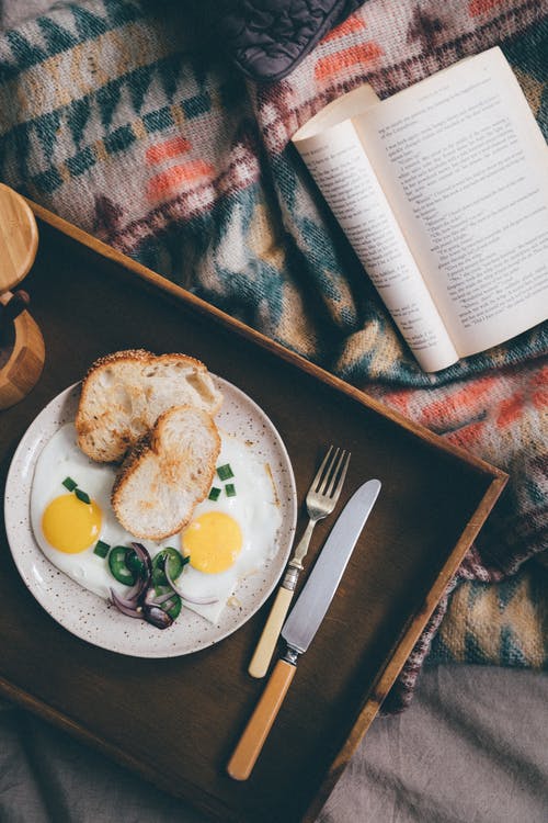 在书附近的木托盘上的美味早餐 · 免费素材图片