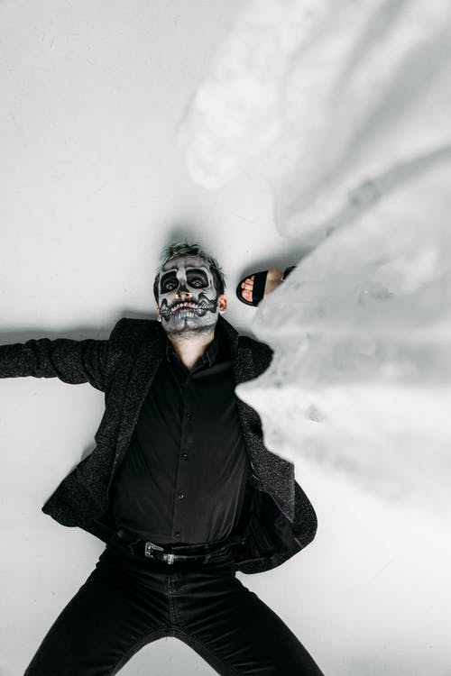 黑与可怕的脸漆躺在地板上的男人 · 免费素材图片