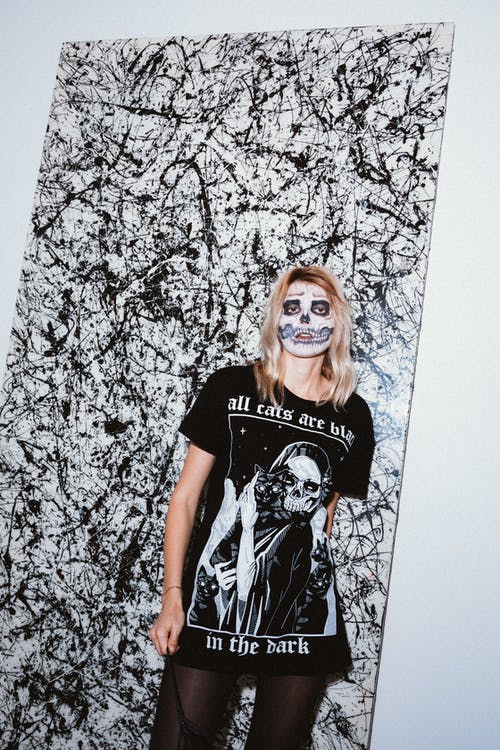 黑色和白色的圆领t恤站在白墙旁边的女人 · 免费素材图片