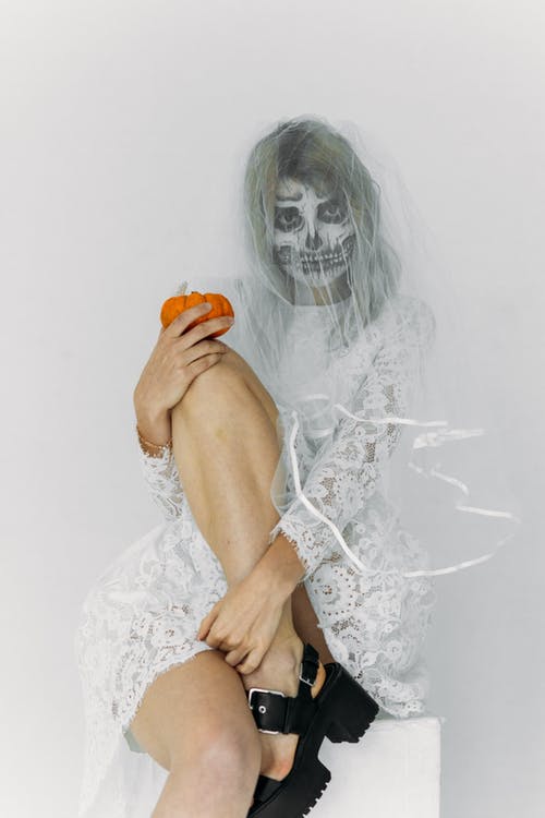 拿着橙色南瓜的白色蕾丝连衣裙的女人 · 免费素材图片