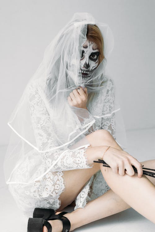 白色蕾丝连衣裙和头骨面漆的女人 · 免费素材图片