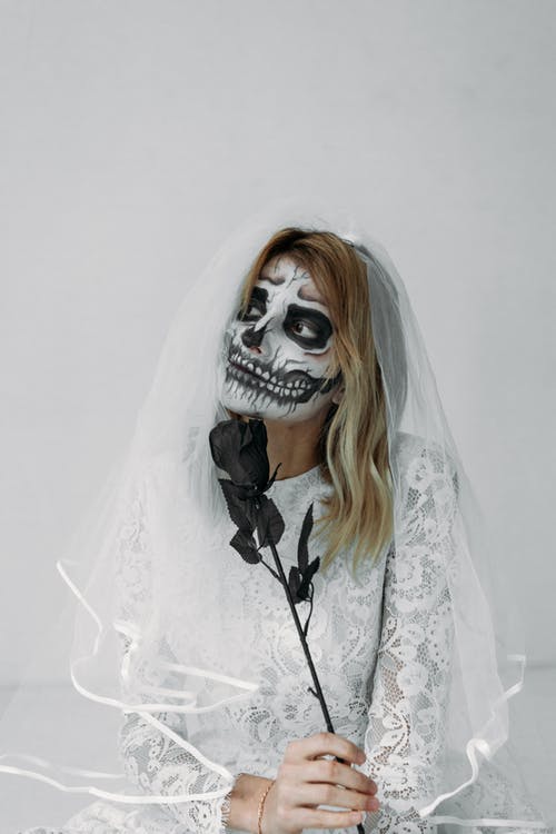 戴着骷髅面具的白色蕾丝连衣裙的女人 · 免费素材图片