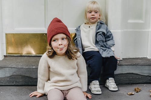 2女孩戴着针织帽坐在混凝土长凳上 · 免费素材图片