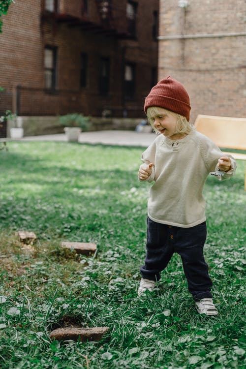 白色长袖衬衫和黑色的裤子，站在绿色的草地上的孩子 · 免费素材图片