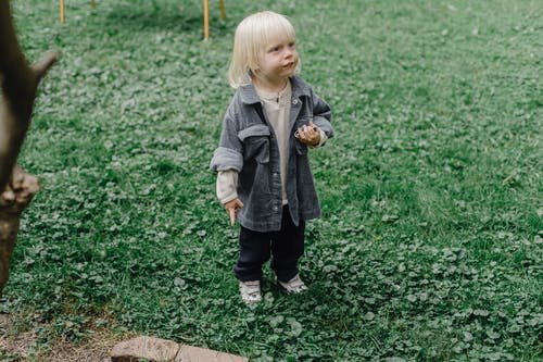 站在绿草地上的灰色外套的女孩 · 免费素材图片