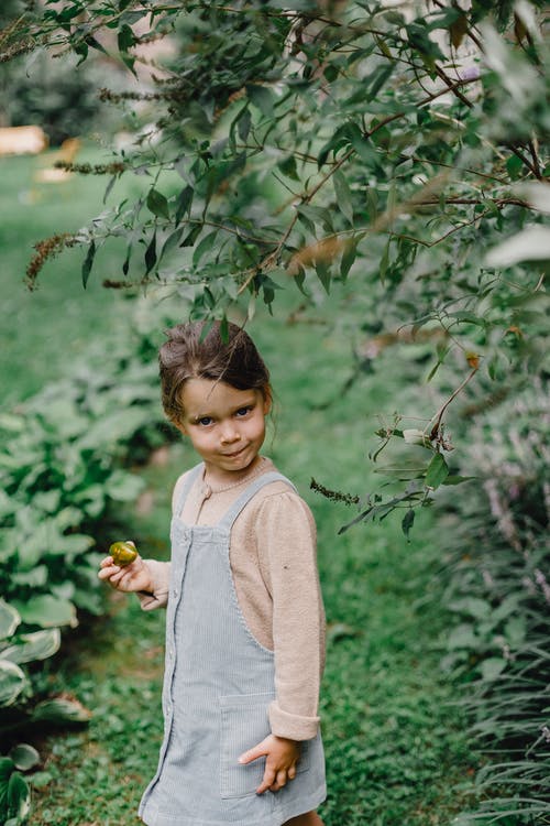 米色长袖衬衫站在绿树下的女孩 · 免费素材图片