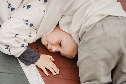 婴儿躺在棕色木地板上的白色和黑色的奥妮 · 免费素材图片