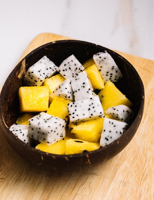在黑色陶瓷碗上切水果 · 免费素材图片