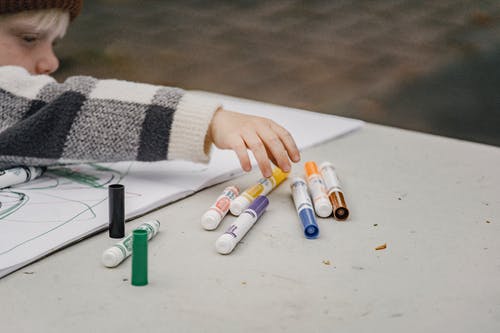 拿着白色和橙色的塑料瓶的人 · 免费素材图片