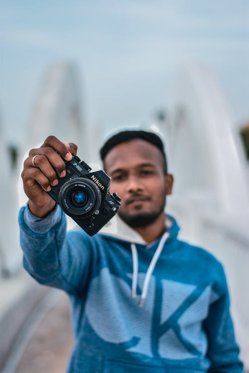 有关3C用品, 人, 垂直拍摄的免费素材图片