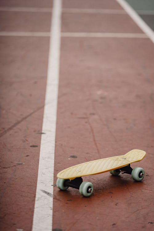 棕色的水泥地板上的棕色滑板 · 免费素材图片