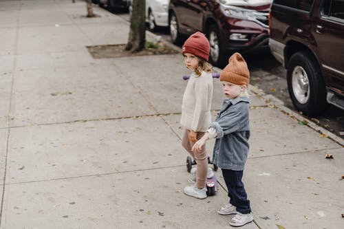 白色外套和蓝色牛仔牛仔裤在人行道上行走的孩子 · 免费素材图片