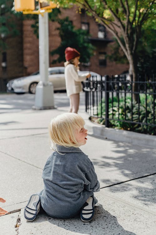 灰色衬衫和红色的帽子，站在人行道上的女孩 · 免费素材图片