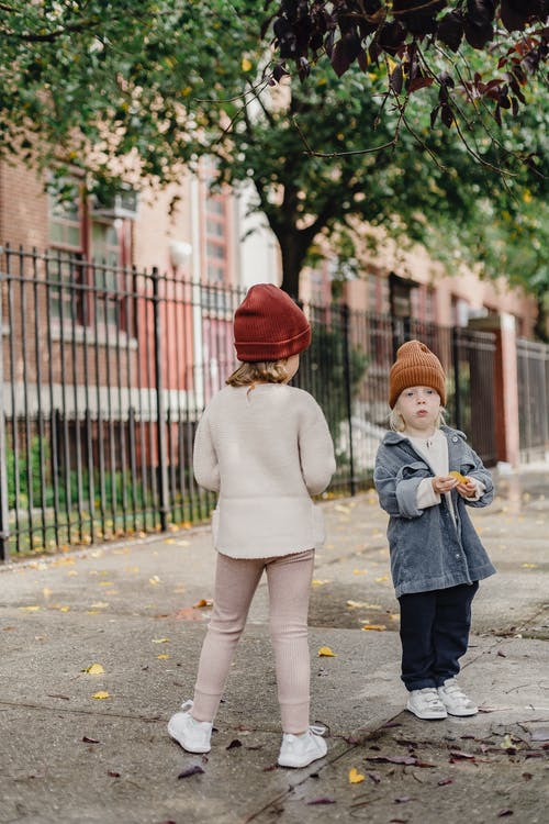 白色长袖衬衫和红色针织帽站在灰色的混凝土路上的女孩 · 免费素材图片