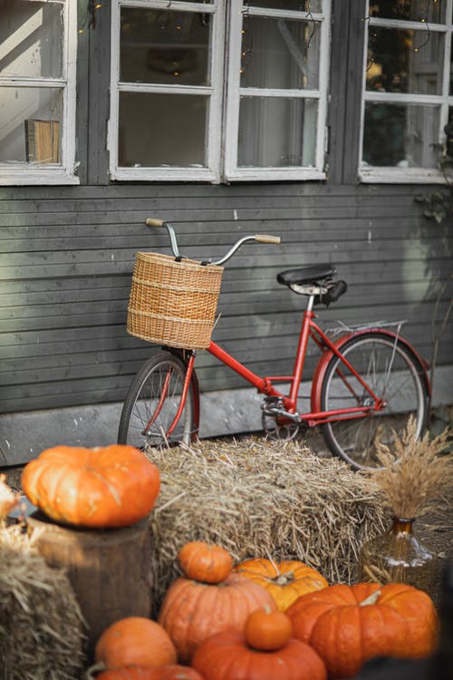 红色城市自行车停在木墙旁边 · 免费素材图片