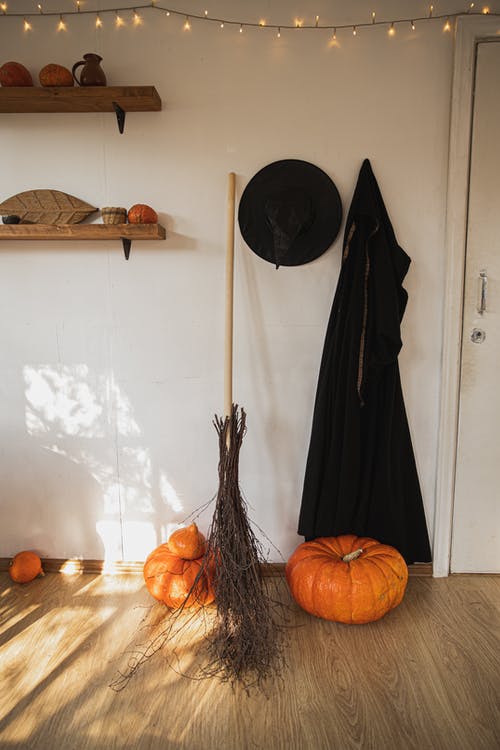 女巫服装和南瓜在一个房间里 · 免费素材图片
