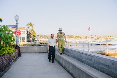 男人和女人在灰色的混凝土长凳上行走 · 免费素材图片