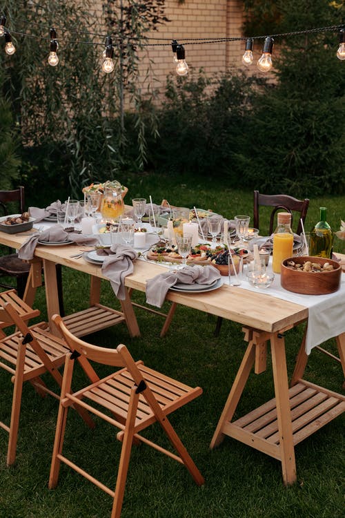 棕色的木桌，椅子和盘子上的食物 · 免费素材图片