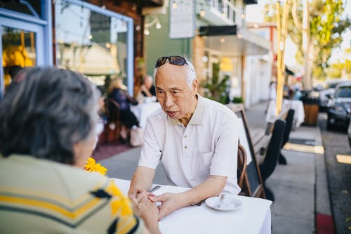 衬衫穿黑色框的太阳镜，坐在椅子上的白色按钮的人 · 免费素材图片