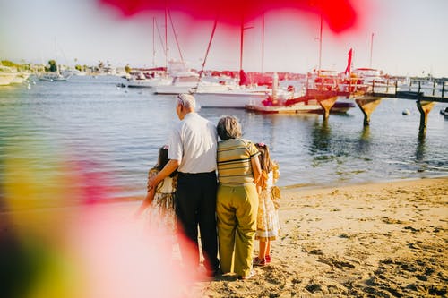 爷爷奶奶和他们的孙女站在岸边 · 免费素材图片