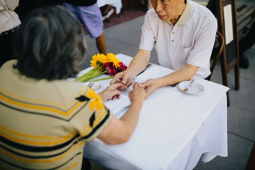 老夫妇手牵着手在桌子上 · 免费素材图片