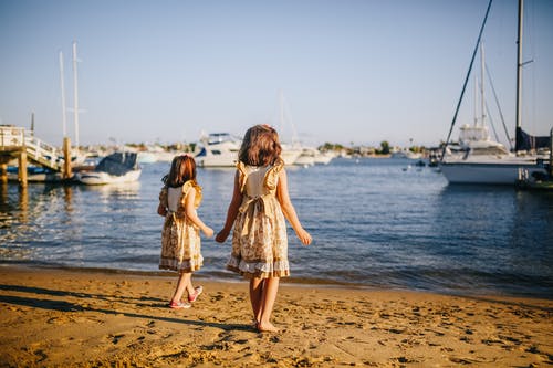 白色和棕色的花裙子，站在海滩上的女孩 · 免费素材图片
