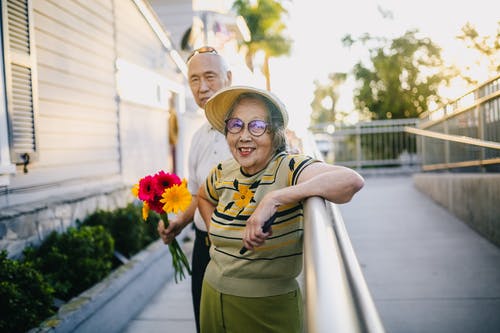 老人抱着花束与他的妻子微笑 · 免费素材图片