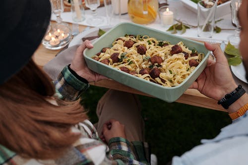 拿着白色塑料容器与食物的人 · 免费素材图片