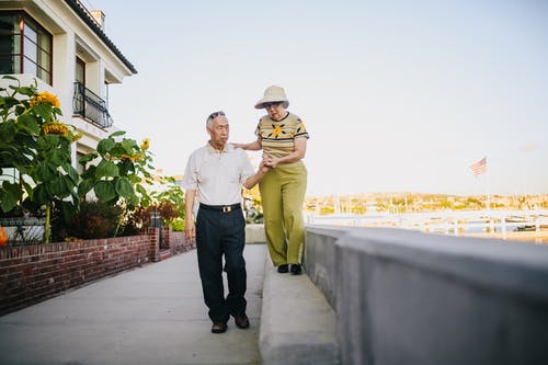 男人和女人在灰色的混凝土长凳上行走 · 免费素材图片